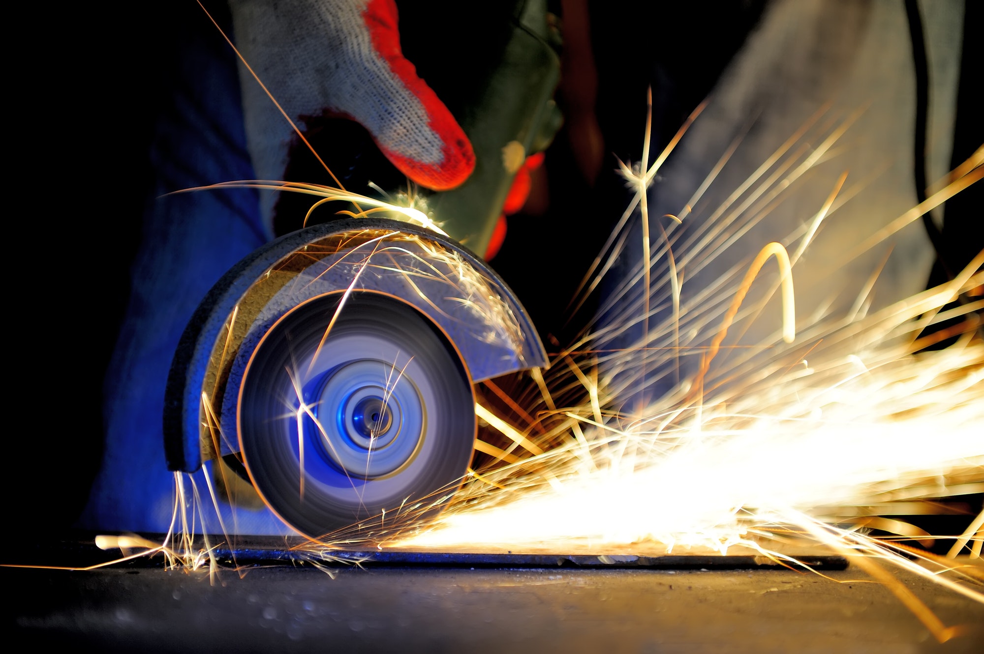 Worker cutting metal with grinder